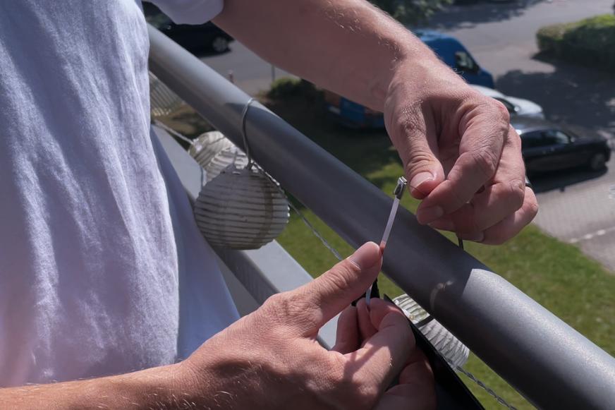 Das Solago Balkonkraftwerk leicht und flexibles Solarmodul wird mit einem Edelstahlkabelbinder am Balkongeländer befestigt.